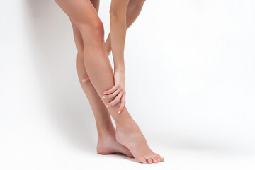 Female caucasian legs and feet on white background - focus on smooth skin and graceful stance