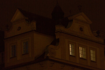 Facades of historic buildings in darkness, intricate architectural details. Charm of nighttime...