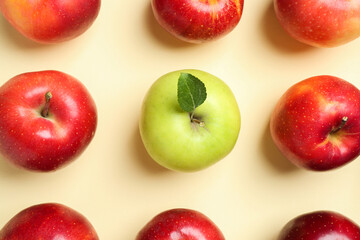 Red apples and green one on beige background, flat lay
