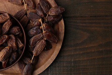 Tasty dried dates on wooden table, top view. Space for text