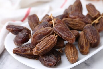 Tasty dried dates on white marble table