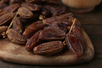 Tasty dried dates on wooden table, closeup