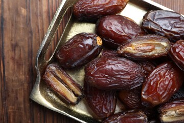 Many tasty dried dates on wooden table, top view