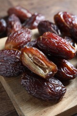 Many tasty dried dates on wooden table, closeup