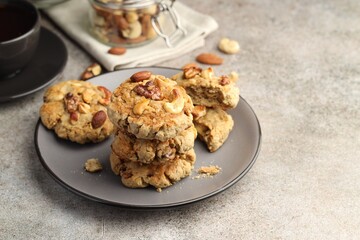 Tasty cookies with nuts on gray textured table, closeup