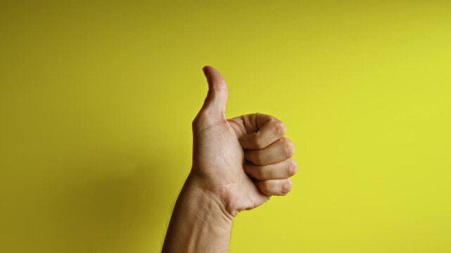 Hand showing different finger gestures against a vibrant yellow background, highlighting various hand expressions.