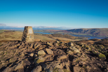 Triangulation pillar at the top of Gowbarrow Fell, overlooking Ullswater, Lake District, UK