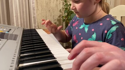 A young music teacher guides a child in learning to play the musical instrument indoors. They focus on mastering the basics of music, fostering creativity and skill development