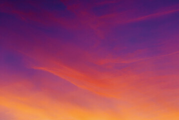 Stunning sunset sky. The sky is painted with vibrant shades of orange, pink, and purple, creating a picturesque and dramatic view. Horizontal clouds add texture and depth to the scene