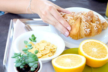 Close up of female hand taking a breakfast croissant