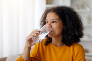 Young African American Female Drinking Clean Mineral Water From Glass At Home, Healthy Beverage,...