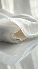 Close-up of white fabric with delicate folds and reflections, creating a serene and minimalist aesthetic.