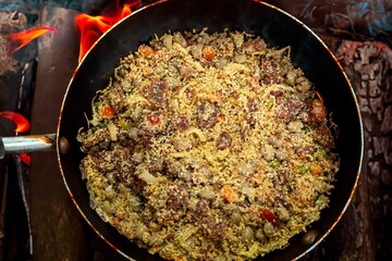 Traditional Brazilian farofa prepared with toasted cassava flour, bacon, onion and typical spices. Brazilian food