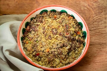 Traditional Brazilian farofa prepared with toasted cassava flour, bacon, onion and typical spices. Brazilian food