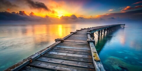 Obraz premium Weathered Wooden Pier Extending into Misty Ocean at Sunset - Conceptual Photography