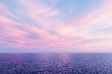 Fototapeta premium Serene ocean under pink and blue gradient sky with a distant ship.