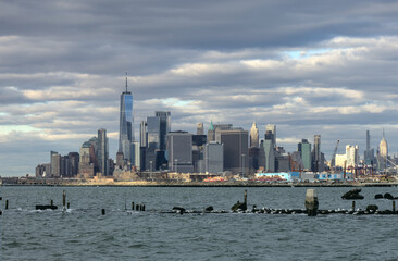 manhattan new york city skyline view from bush terminal park brookyn (downtown financial center skyscraper) dramatic sky clouds light sunset waterfront harbor river pier long exposure travel tourism