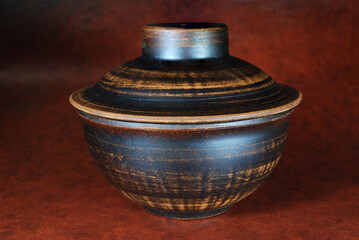 red clay food bowl with lid on terracotta background