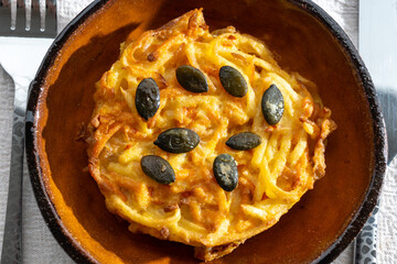 Pumpkin grated roasted patties, rosti or latkes, made fron squash and potato decorated with pumpkin seeds