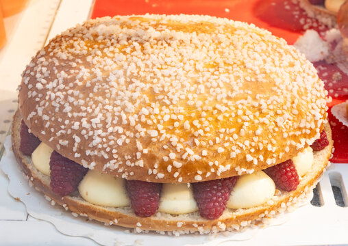Cake Tarte tropezienne or La Tarte de Saint-Tropez - dessert pastry consisting of filled brioche with cream and fresh red berries
