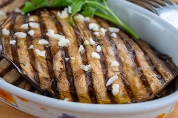 Italian style starter served in restaurant, grilled eggplant with garlic, olive oil and fresh parsley