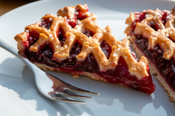 Homemade open sour cherry pie, delicious sweet dessert served in pieces outdoor in garden