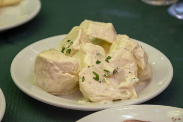 Vegetarian Spanish food, boiled potatoes with alioli sauce and parsley served as tapa in old tavern, Andalusia, Spain