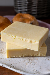 Block of aged cheddar cheese, the most popular type of cheese in United Kingdom and USA, natural cheese from cow milk