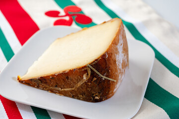 Piece of tasty Basque Brebis Fume smoked sheep cheese produced in south-western France, Northern...