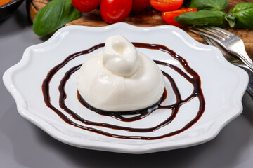 Cheese collection, fresh soft white burrata cheese ball made from mozzarella and cream served with balsamic vinegar from Modena, Italy, close up