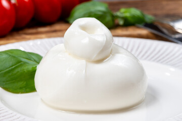 Cheese collection, fresh soft white burrata cheese ball made from mozzarella and cream from Apulia, Italy, close up
