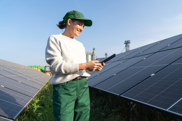 Female farmer with digital tablet on a modern farm using solar panels