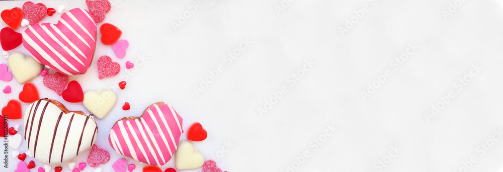 Poster valentines day heart shaped sweets corner border with donuts and candies. above view on a white marb