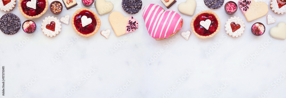 Poster valentines day baking top border with a variety of cookies, chocolates and sweets. above view on a w