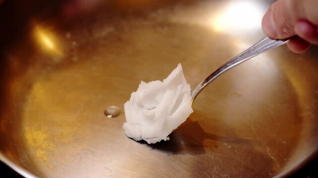 plan fixe vid&eacute;o sur une poile inox avec du gras de coco qui fond au contact de la po&ecirc;le chaude