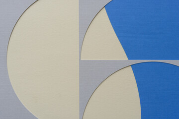 sophisticated machine-cut paper stencil with semi-circular cutout shapes on beige and blue paper