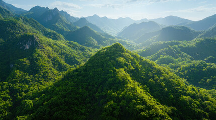 Naklejka premium Lush Green Mountains and Valleys Under Bright Blue Sky in Nature
