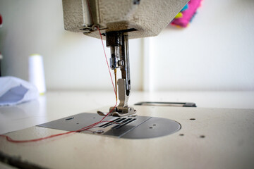 A detailed close-up of the sewing machine needle and stitch plate, capturing the precision of this essential tool for crafting, tailoring, and fashion design. This image emphasizes the intricacies of