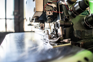 A detailed close-up of the sewing machine needle and stitch plate, capturing the precision of this essential tool for crafting, tailoring, and fashion design. This image emphasizes the intricacies of