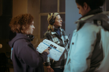 A female director at work on the set. The director works with a band or with a speaker during the...