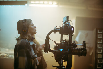 The director of photography is a woman behind a video camera on the set. A professional...