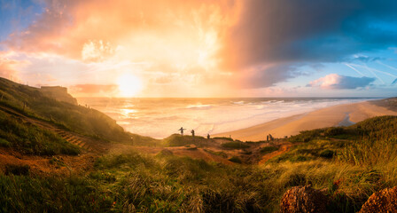 Panoramic view of Nazare beach, people watching waves during sunset, Portugal