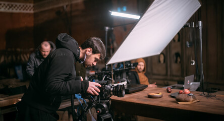 Director of photography with a camera in his hands on the set.  Filming process indoors, studio