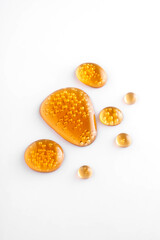 Gold collagen serum bubbles. Cosmetic essence. Concept skincare cosmetics solution on white background