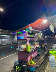 Street vendor carts or PKL on the side of Indonesian highways, at night.