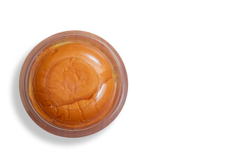Round butter bun enclosed in plastic packaging on white background