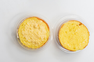 Top view of split butter bun slices in clear plastic containers, Close Up
