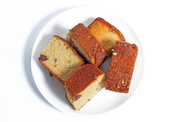 Slices of homemade cake with nuts on a white plate, top view