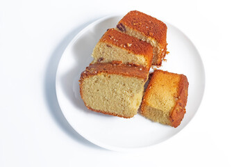 Four slices of freshly baked sponge cake on a white plate, top view