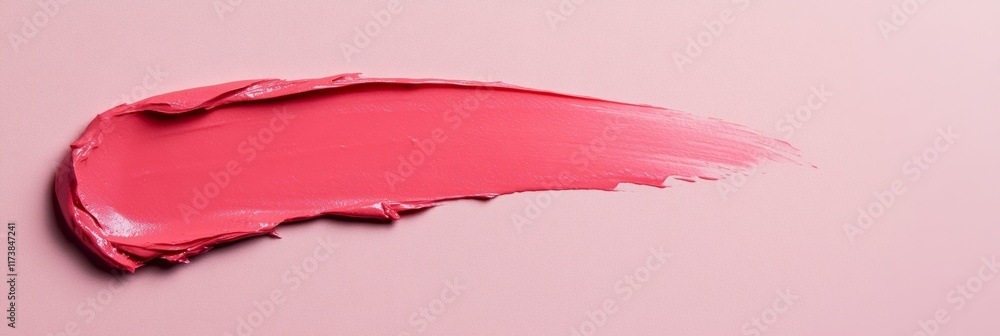 Poster pink lipstick is smeared on a pink background, creating a textured and visually appealing swatch tha